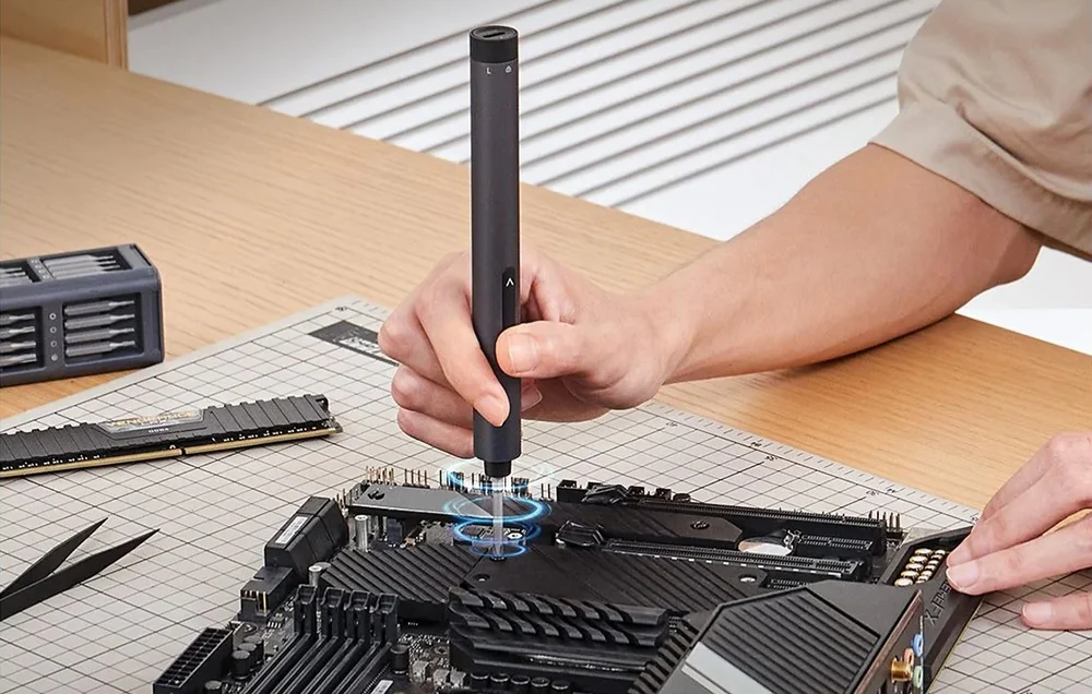 A man repairs a device with a precision screwdriver.