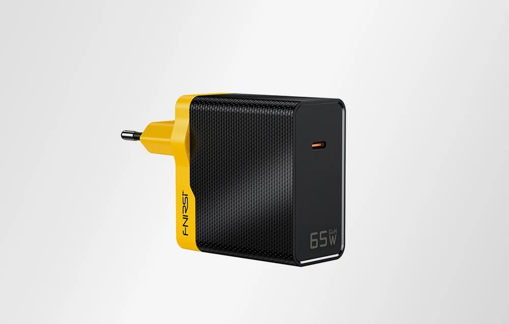 Black and yellow power adapter on a gray background