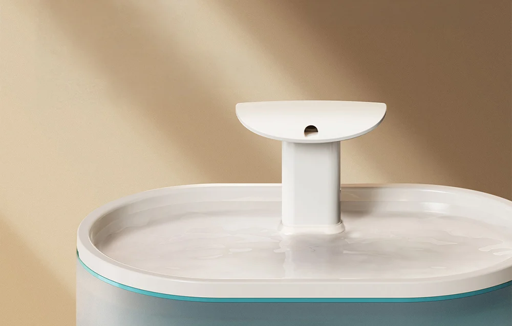 Close-up of the top part of the water fountain with a plastic surface and a central nozzle.
