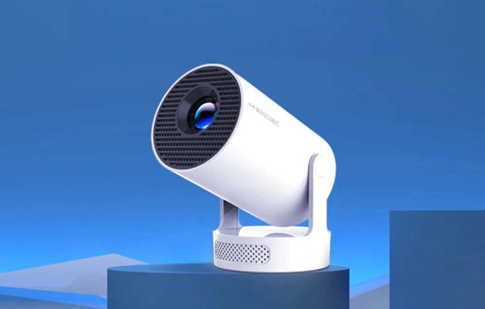 A white projector set on a dark blue, geometric platform against a solid blue sky