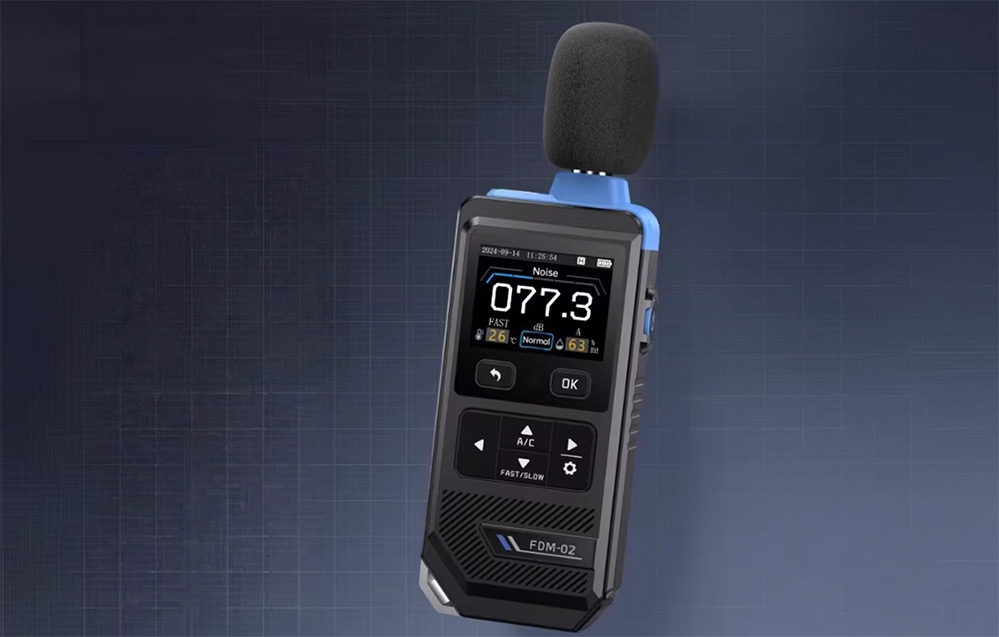 Portable decibel meter with a foam-covered microphone, displaying a reading of 77.3 dB on a dark, textured background