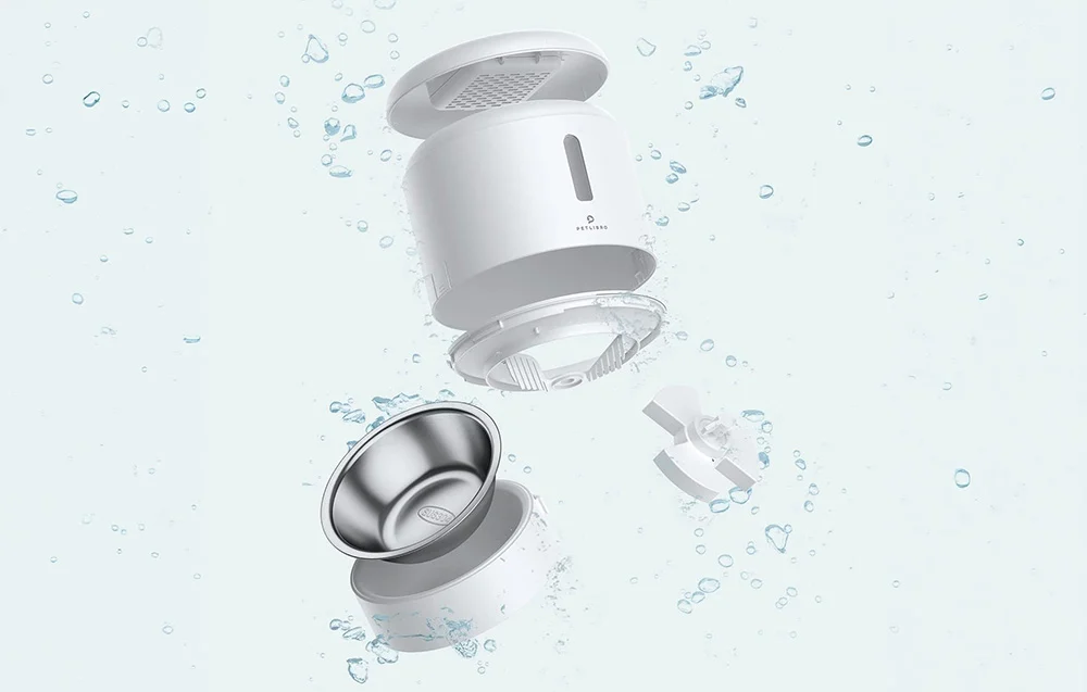 Disassembled parts of a white automatic cat feeder and a metal bowl shown against a background with water droplets
