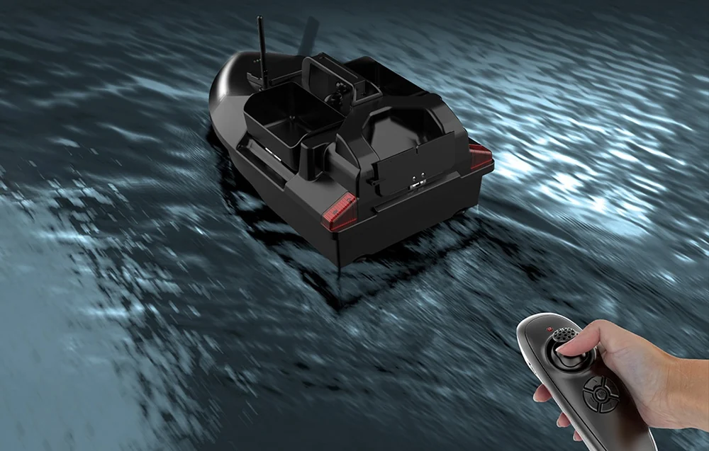 Black RC bait boat in fast motion on dark water, hand holding remote control in lower right corner