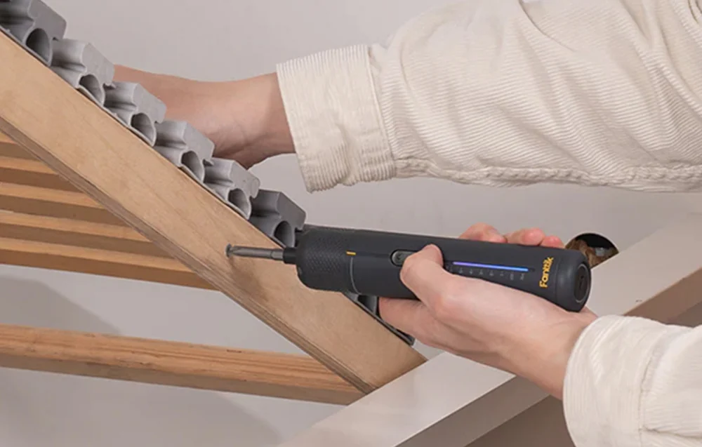 Assembling a wooden bed frame using a slim electric screwdriver with LEDs
