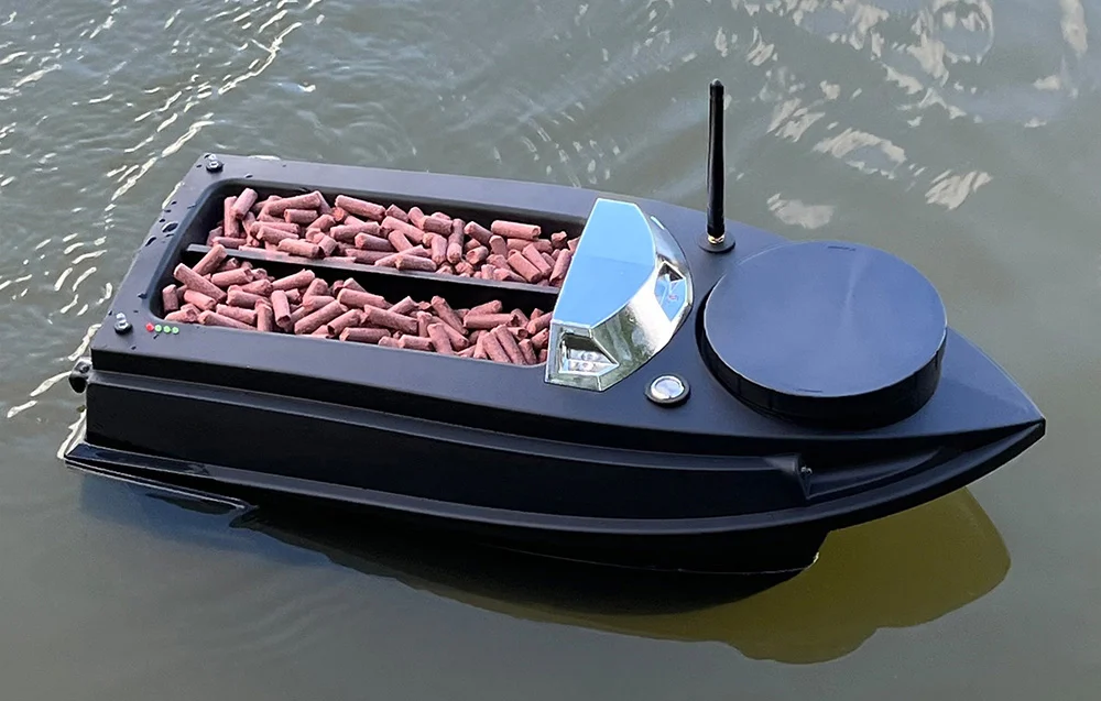 A long black bait boat moving quickly across the water with fish bait