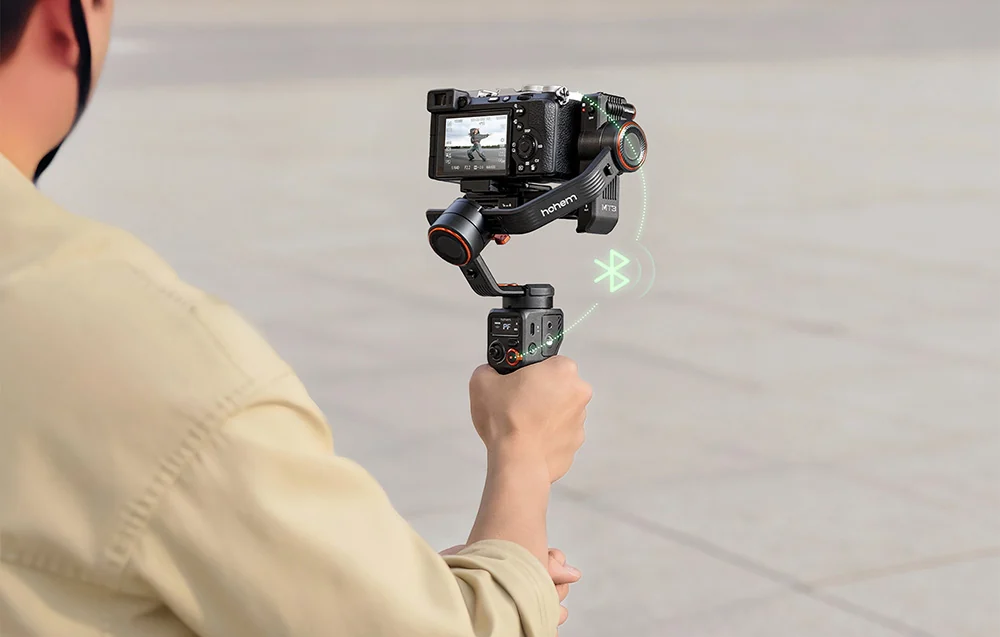 A boy holding a gimbal with a camera