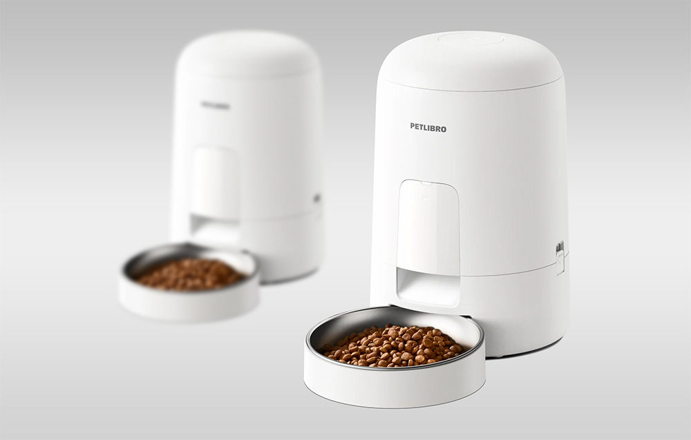 Two white Petlibro smart feeders on a gray background