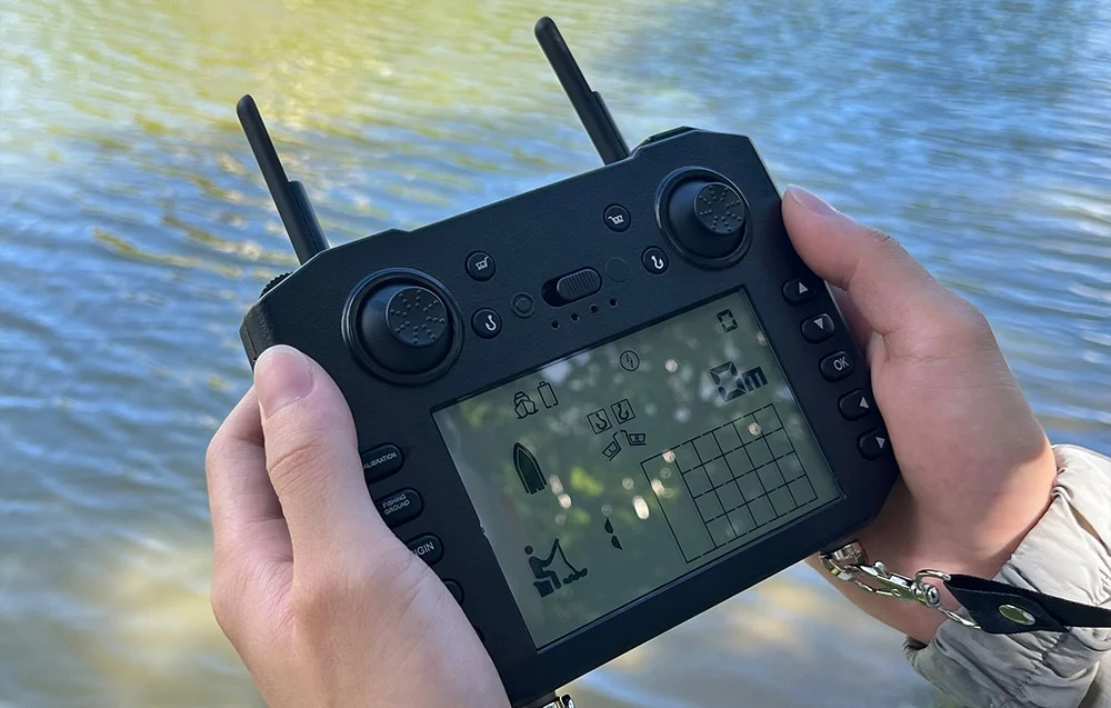 Hands holding a remote control with an LCD display showing the boat and data above the water