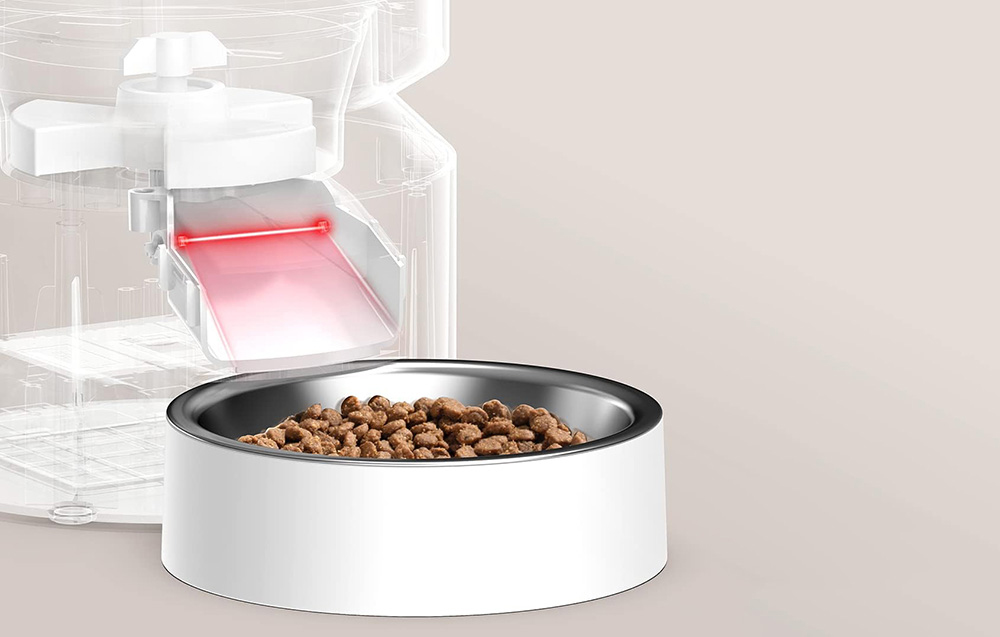 Close-up of a bowl of dry food placed under the automatic feeder’s dispenser with the food outlet sensor highlighted