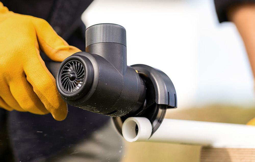 Cordless angle grinder cutting a pipe