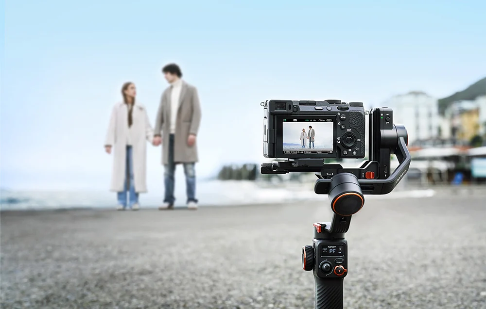 A camera mounted on a gimbal recording a couple holding hands