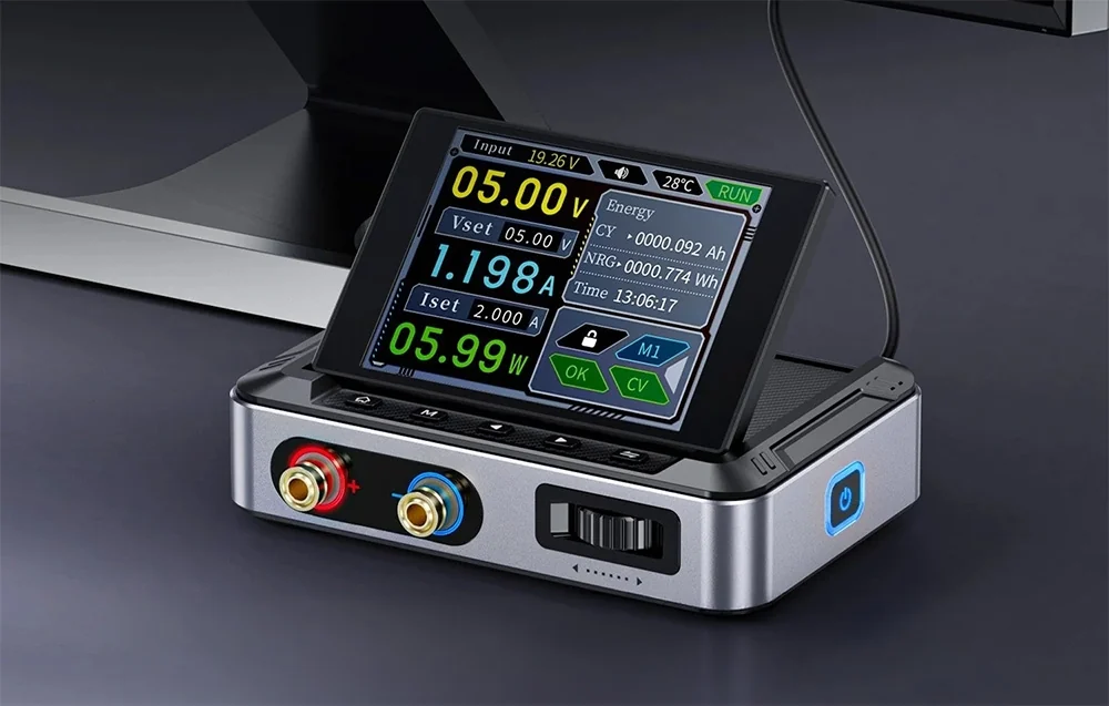 FNIRSI power supply with a silver housing, raised display screen, and two front output jacks.