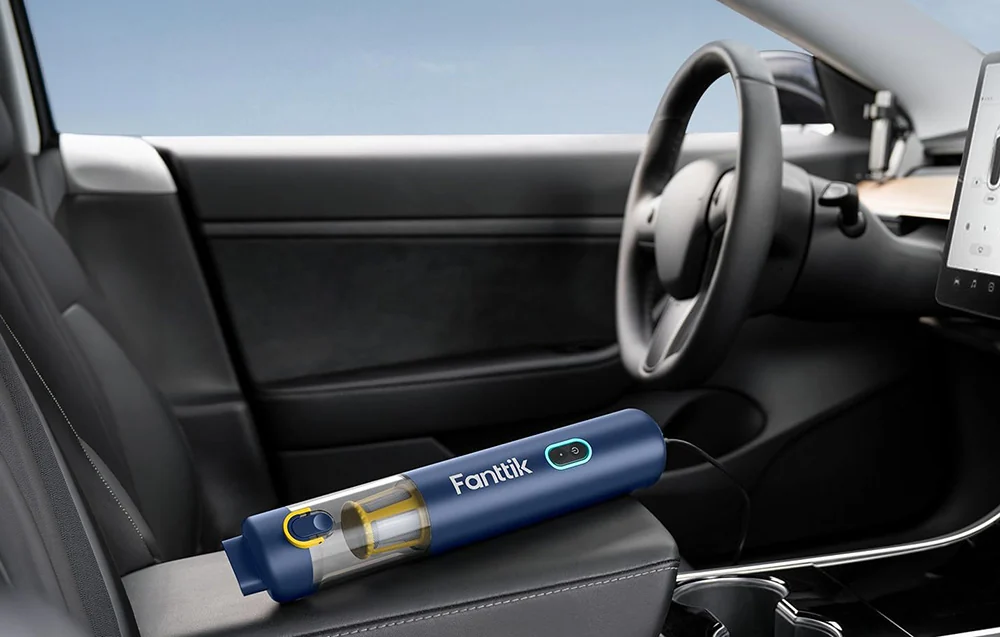 The Fanttik cordless vacuum cleaner rests on the armrest inside the car.