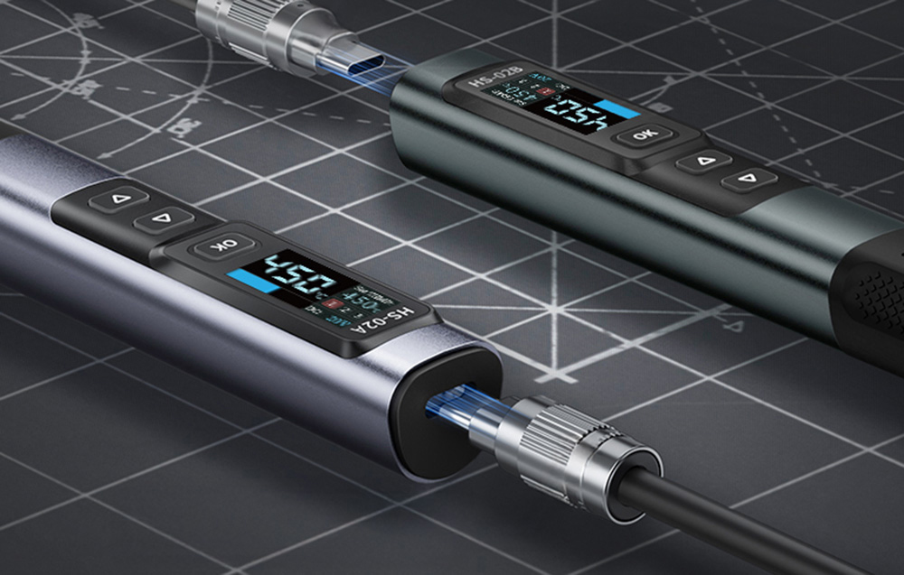 Two FNIRSI soldering irons on a dark soldering mat.