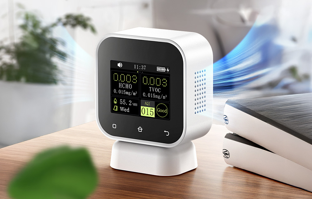 Air quality monitor on a wooden desk displaying HCHO, TVOC, humidity, and AQI parameters.