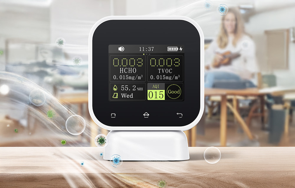 Air quality monitor in a studio with floating particles in the background.