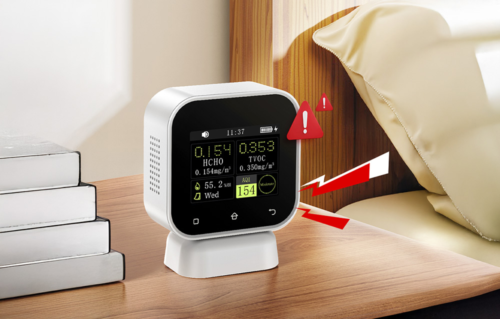 Air quality monitor by the bed displaying a warning about elevated pollution levels.
